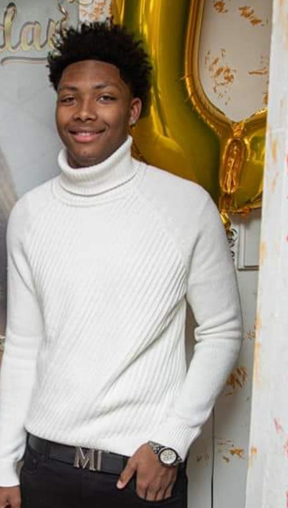 Joshua J. Bagley - black man in white sweater